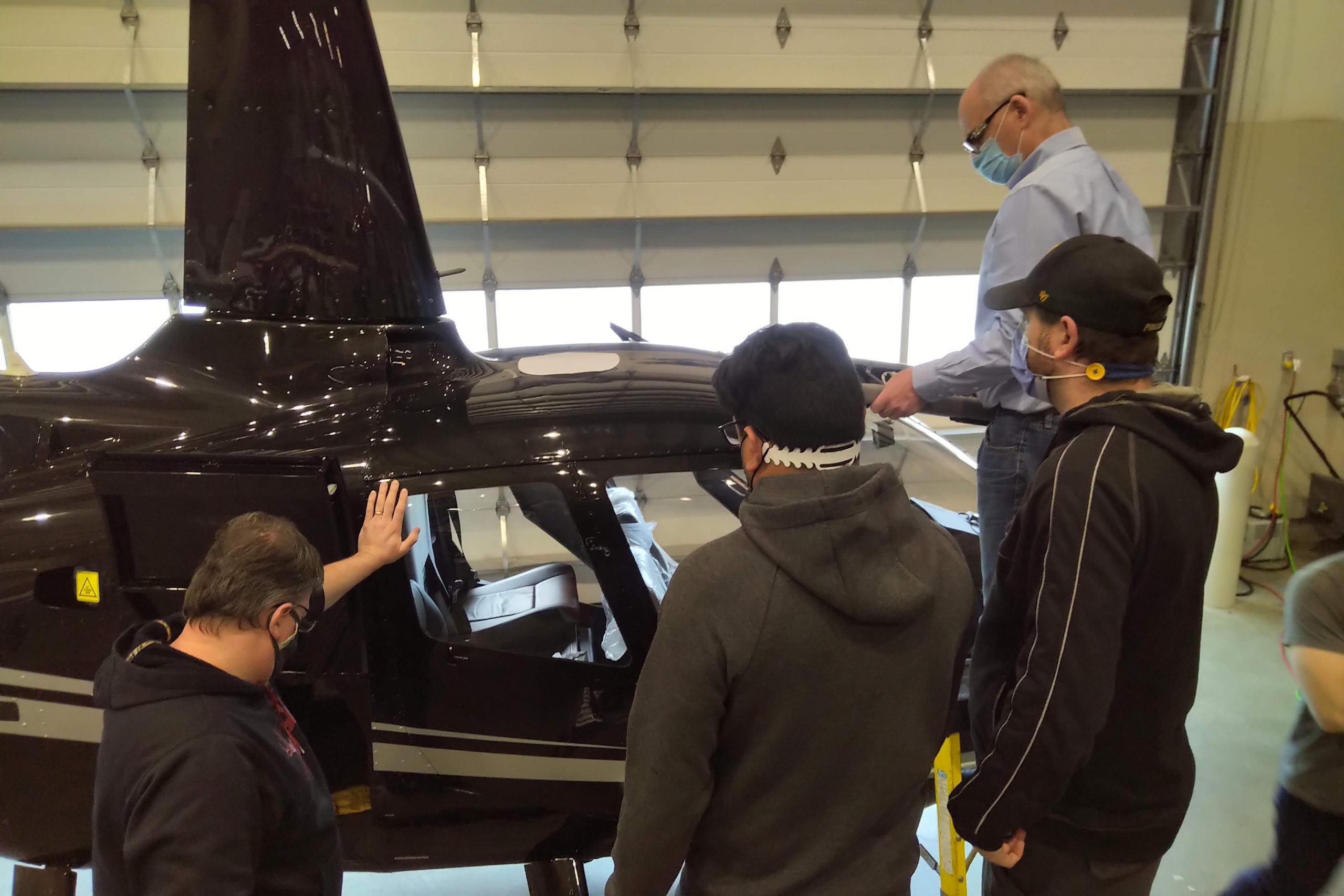 Multiple Maxcraft Employees Gather Around the R66 with a Template of the Traffic Antenna