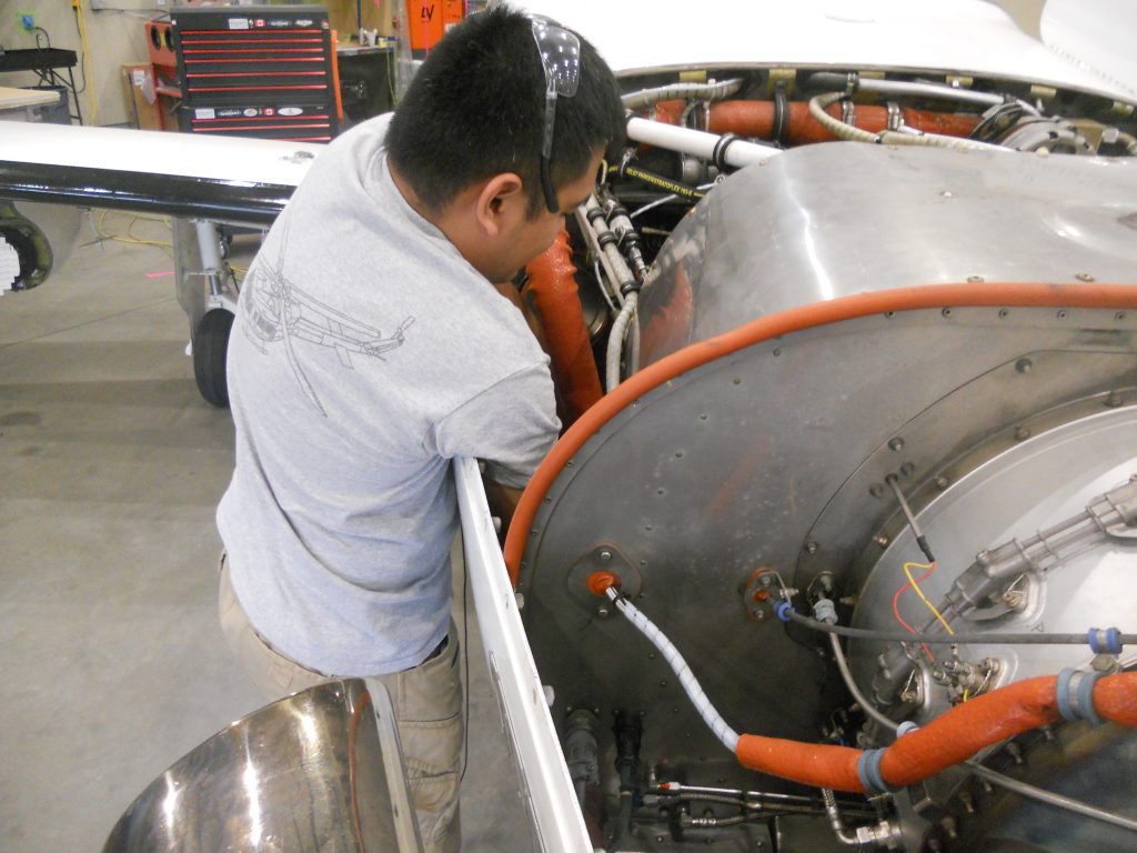 A Maxcraft Technician Routing Wires to the Engine Bay