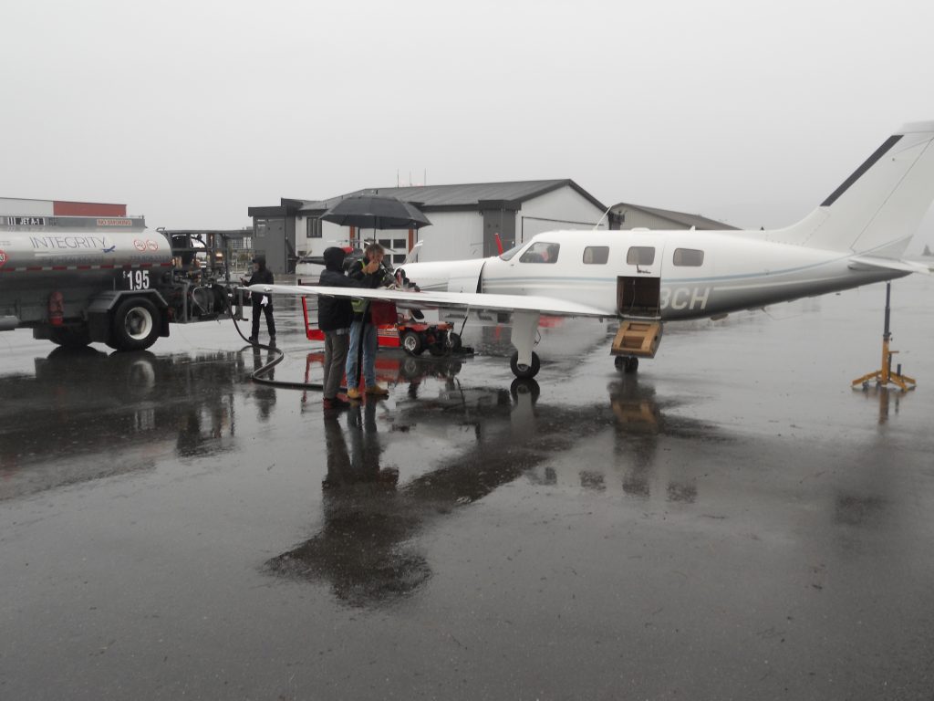 The Aircraft During Fuel Calibration on a Rainy Day in Vancouver(One Apprentice was Given the Important Task of Keeping the Airport Fueler Dry[er] During this Process) 